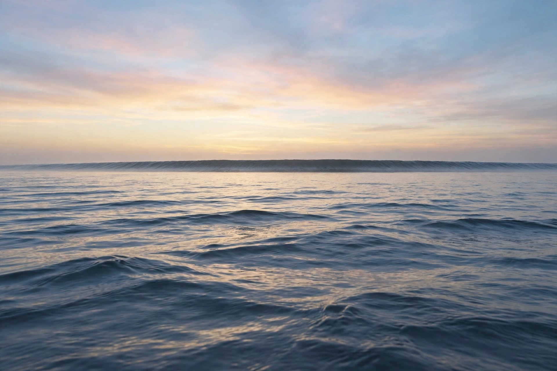 A set rising on the horizon at dawn, seen from the water